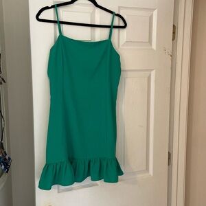 Tight green dress with a ruffle at the bottom.